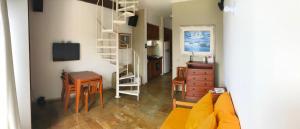 una sala de estar con escritorio y una habitación con mesa en Apartamento Duplex Angra Inn en Angra dos Reis