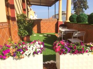 um pátio com flores, uma mesa e cadeiras em Apartment with private patio em Fuengirola