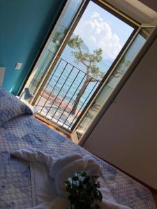 Dormitorio con ventana grande y cama con planta en Hotel Mojito en Domaso
