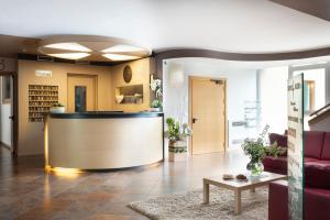 a lobby with a reception desk in a building at Vital Hotel Flora in Comano Terme