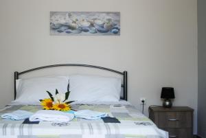 a bedroom with a bed with a flower on it at Soula's Sunshine Green Apartment in Néa Karváli