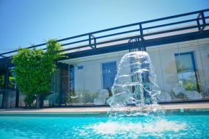 una fuente de agua en una piscina frente a un edificio en Grand Hotel Masseria Santa Lucia, en Ostuni