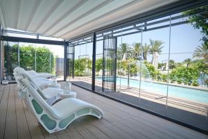 una camera con sedie a sdraio bianche e una piscina di Grand Hotel Masseria Santa Lucia a Ostuni