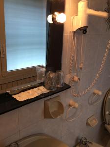 a bathroom with a sink and a mirror and a phone at VILLA ALMA 2 in Bologna