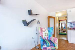 a living room with a chair and a lamp at Apartment Living Colors in Ljubljana