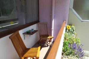 two wooden benches sitting on a balcony with flowers at Apartment Living Colors in Ljubljana