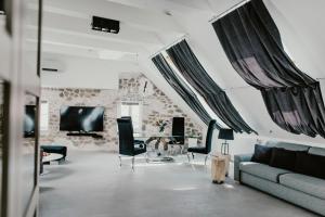 Coco Chanel Boutique Apartment في برنو: غرفة معيشة مع أريكة وتلفزيون