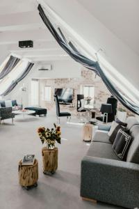 Coco Chanel Boutique Apartment في برنو: غرفة معيشة مع أريكة وطاولات وكراسي