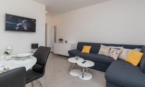 sala de estar con sofá azul y mesa en Apartment Matea en Trogir