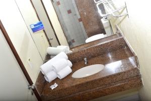 a bathroom counter with a sink and a mirror at Natal Praia Hotel in Natal