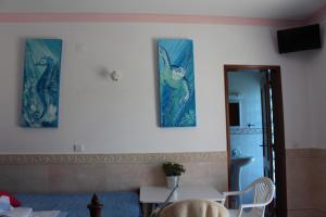 a living room with three pictures on the wall at Sagres Sunny Room with private bathroom 300m from the beach in Sagres