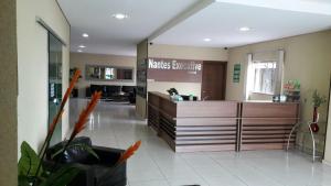 a large kitchen with a counter in a room at Nantes Executive Hotel in Pitanga