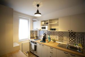 a kitchen with white cabinets and a sink and a window at SMP apartment 3 in Timişoara