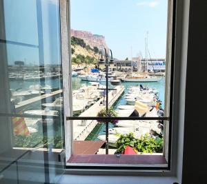 a window with a view of a marina with boats at Le Palmyre in Cassis