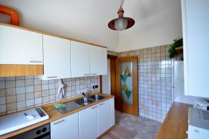 Villa Petra Chiara في لوكوروتوندو: مطبخ مع دواليب بيضاء ومغسلة