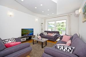a living room with two couches and a tv at Luxurious, modern and spacious apartment with terraces in Tugare