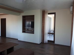 a living room with a tv on a white wall at Gradina in Chernomorets