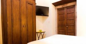 1 dormitorio con 1 cama, TV y armario en Hotel Expres By Hosting House, en Morelia