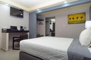 奧里薩巴的住宿－哈酒店，一间卧室配有一张床和一张带笔记本电脑的书桌
