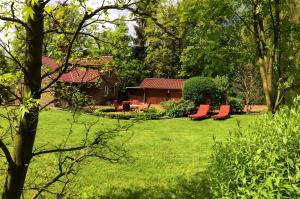 バート・ツヴィッシェンアーンにあるFerienhaus Dreibergenの赤い椅子2脚付きの庭と家