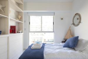 ein Schlafzimmer mit einem Bett mit einer blauen Decke und einem Fenster in der Unterkunft Gorriti Palace in Buenos Aires