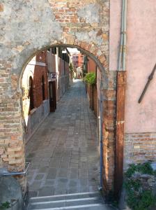 an alley in a building with an archway at Appartamento con vista in Venice