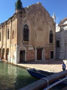 a boat sitting in the water in front of a building at Appartamento con vista in Venice