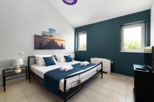 a bedroom with a large bed with blue walls at Villa Sophia in Soroni +15 photos