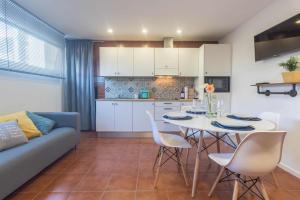 a kitchen and a living room with a table and chairs at Taxa - T2 no centro da cidade - Braga in Braga
