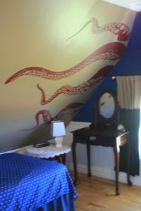 a bedroom with a painting of a dragon on the wall at Simply Charming Cottages in Cavendish