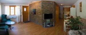 a living room with a brick wall with a tv at Jækta Fjordstue in Mosvik
