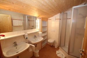 uma casa de banho com um lavatório, um chuveiro e um WC. em Rimmlhof & Rimmlstube em Berwang