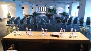 a conference room with chairs and a table with wine glasses at 64rooms in Enna