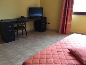 a bedroom with a desk and a bed and a desk with a television at 64rooms in Enna