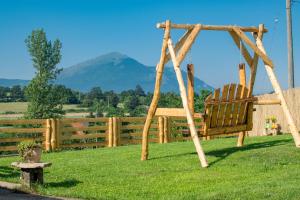 a swing in the grass with a mountain in the background at Rtanjski konak in Boljevac