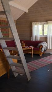 a living room with a red couch and a staircase at Jækta Fjordstue in Mosvik