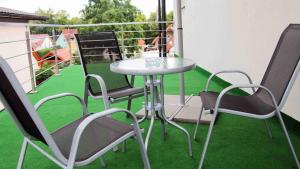 einen Tisch und Stühle auf einem Balkon mit Gras in der Unterkunft Apartmány Hillfort in Bojnice