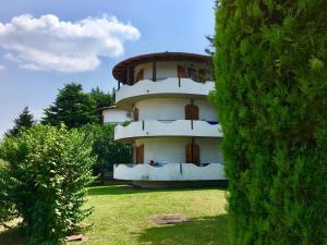 a building in the middle of a yard with a bush at Venere in Peschiera del Garda