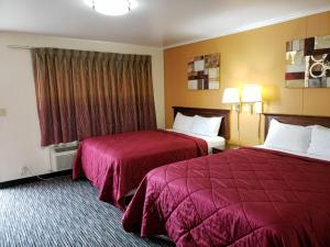 a hotel room with two beds and two lamps at Super 7 Motel in Sedalia