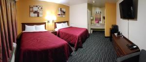 ein Hotelzimmer mit 2 Betten und einem TV in der Unterkunft Super 7 Motel in Sedalia