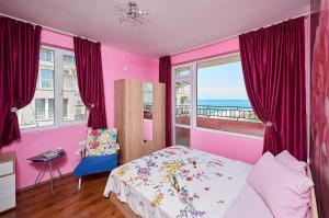 ポモリエにあるApartments Alerinaのピンクのベッドルーム(ベッド付)が備わり、海の景色を望めます。