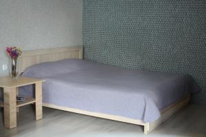 a bedroom with a bed and a table with flowers at Apartment in the center in Chernihiv