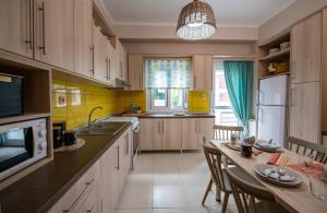 a kitchen with wooden cabinets and a table with chairs at Petite Fleur in Preveza