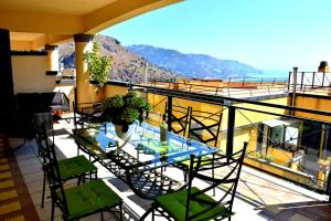 a table and chairs on a balcony with a view of the ocean at Taormina Sunny Apartment - Taormina Holidays in Taormina