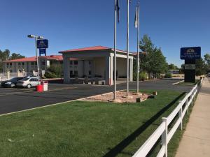 シーダーシティにあるAmericas Best Value Inn Cedar Cityの駐車場前の柵付き建物