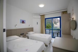 a hotel room with two beds and a balcony at Hotel Turunç-Malmen in Turunc