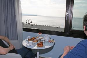 two people sitting in a room with a table with pastries at BB Oasis in Scilla