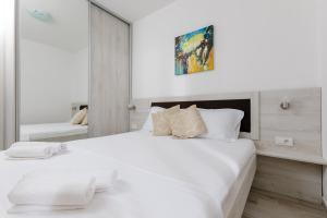ティヴァトにあるApartmani Miaのベッドルーム(鏡付きの大きな白いベッド1台付)