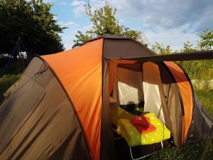 ein orangefarbenes Zelt mit offener Tür auf einem Feld in der Unterkunft Eternahof in Bad Gandersheim