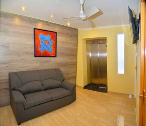 uma sala de estar com um sofá e uma pintura na parede em Hostal Julieta em Lloret de Mar